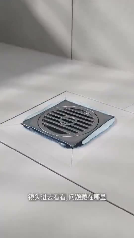 AI 生成的工程视频画面:瓷砖地面上的地漏特写,字幕“镜头进去看看,问题藏在哪里”